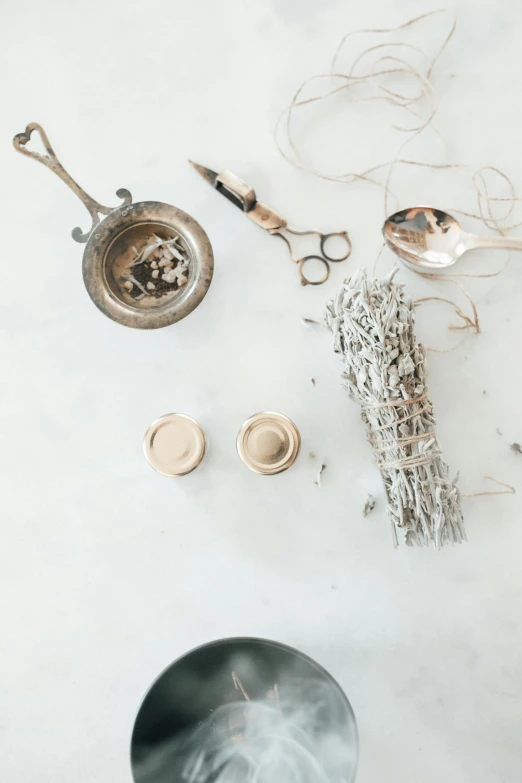 three metal spoons and various silver objects on white surface