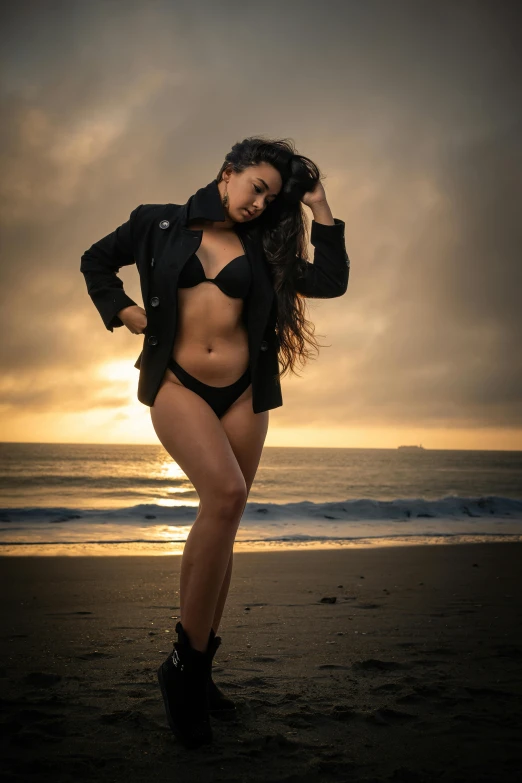 a woman standing in the sand wearing a bikini