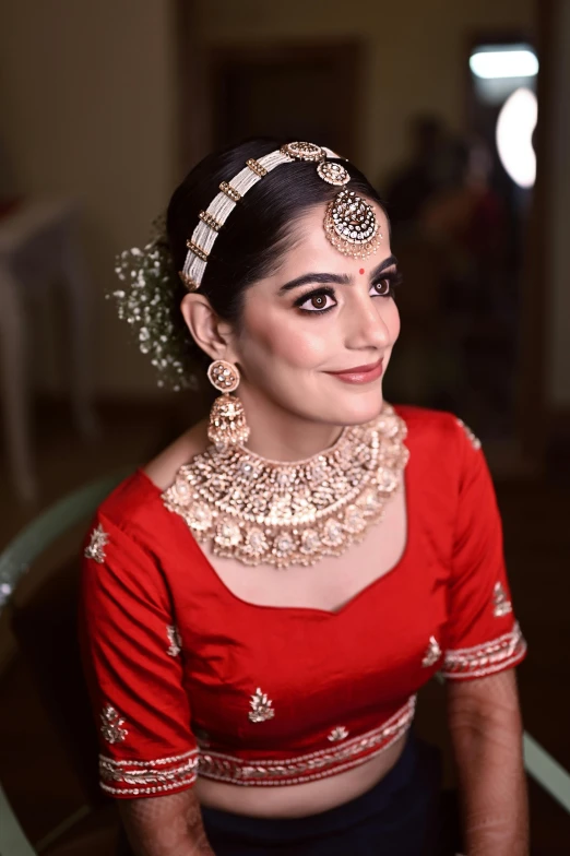 a beautiful indian woman with traditional jewelry looking at the camera