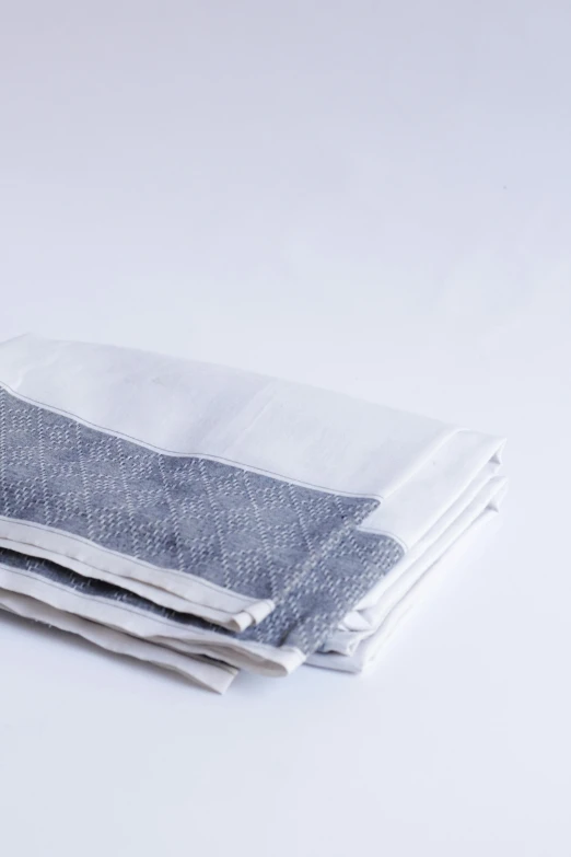 two folded cloths on a white surface