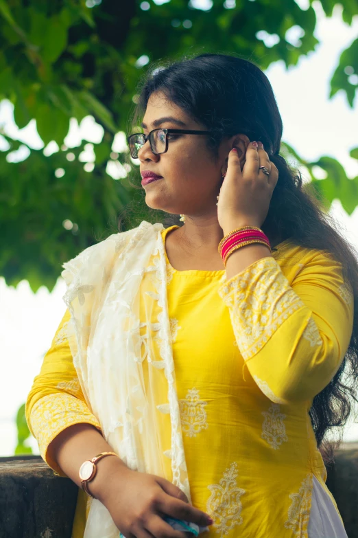 a women in a yellow blouse holding a cell phone