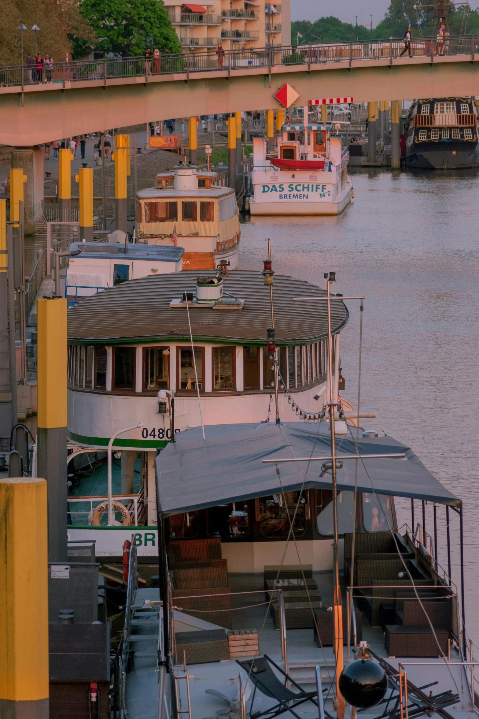 a barge parked next to a dock underneath a bridge