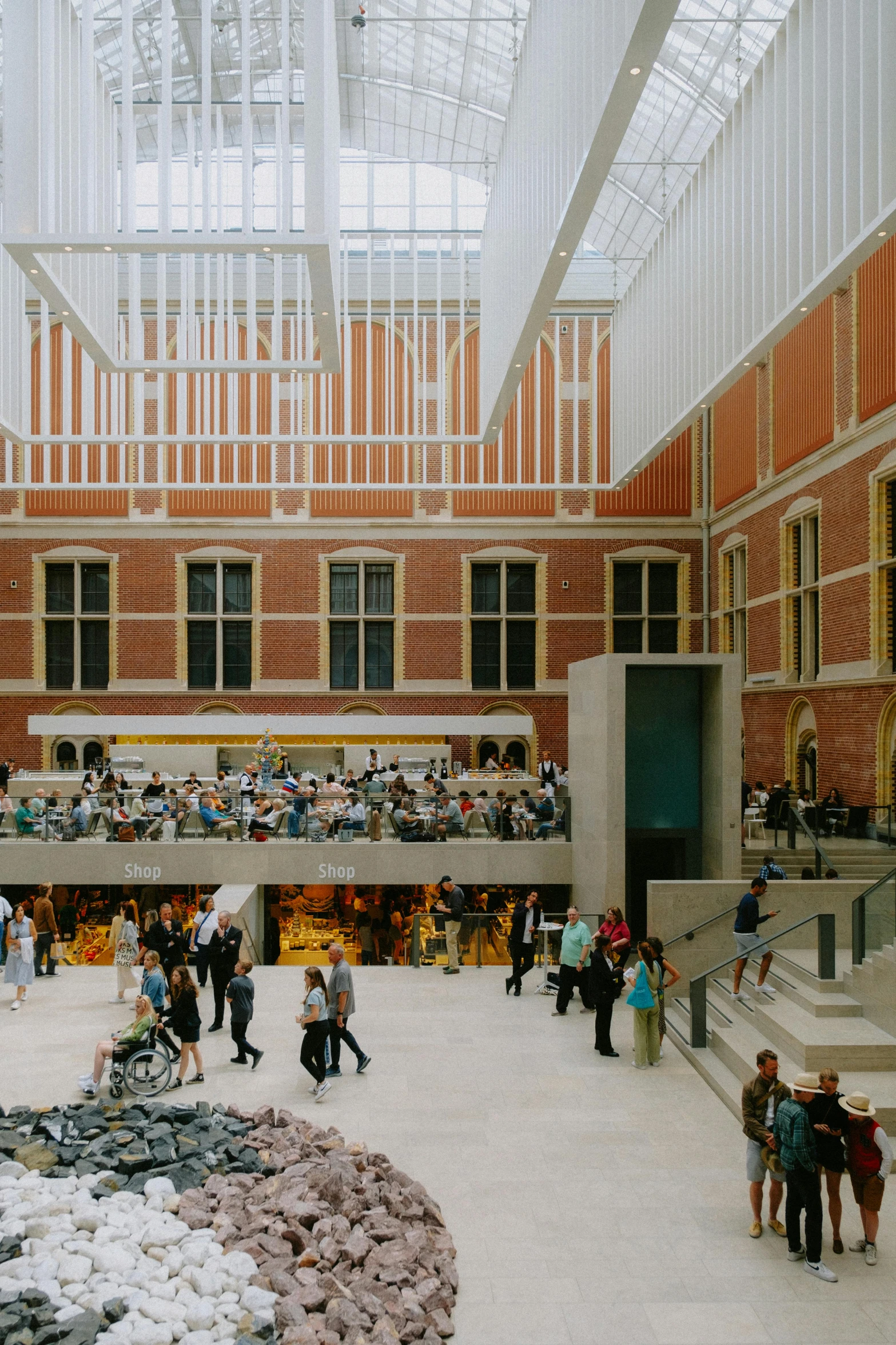 people in a large open area with stairs and a skylight