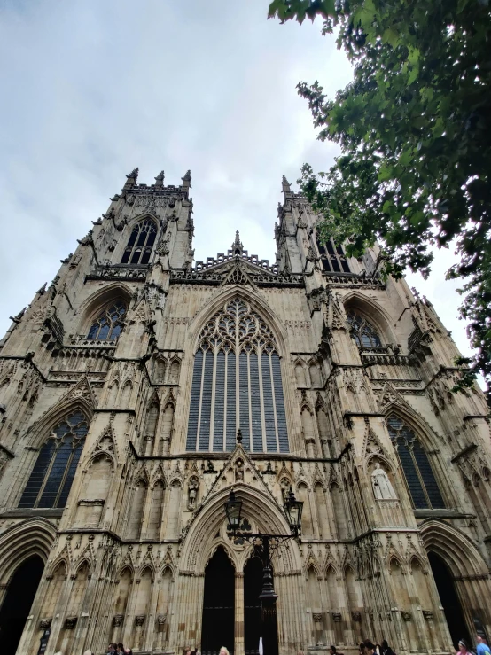 the front of a cathedral with people walking around