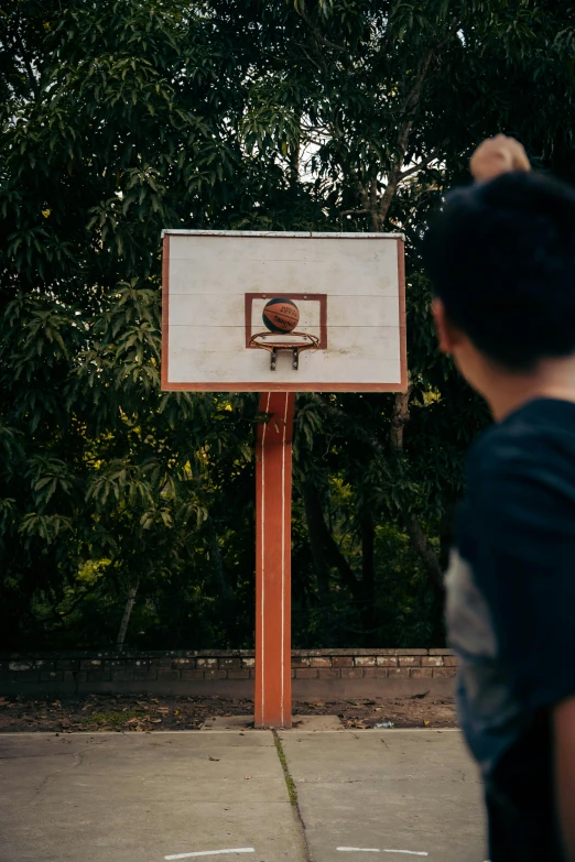 man about to dunk at an outdoor basketball game