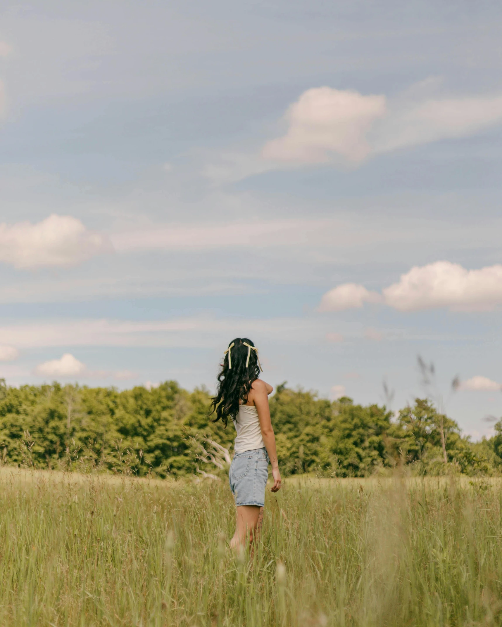 a girl is standing alone in an empty field