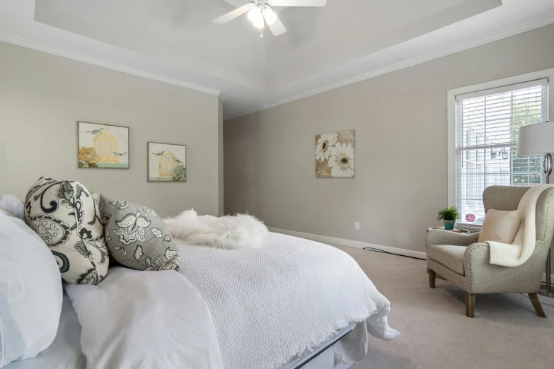 a very neat, clean white bedroom with plenty of pillows