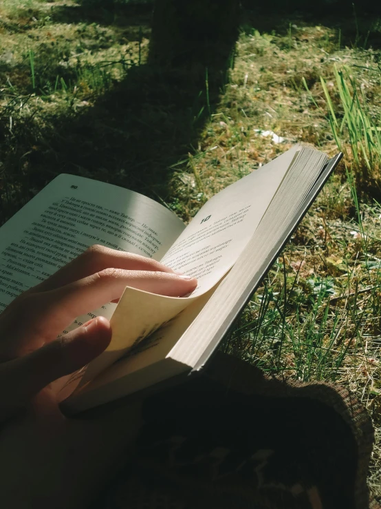 a hand that is holding onto an open book