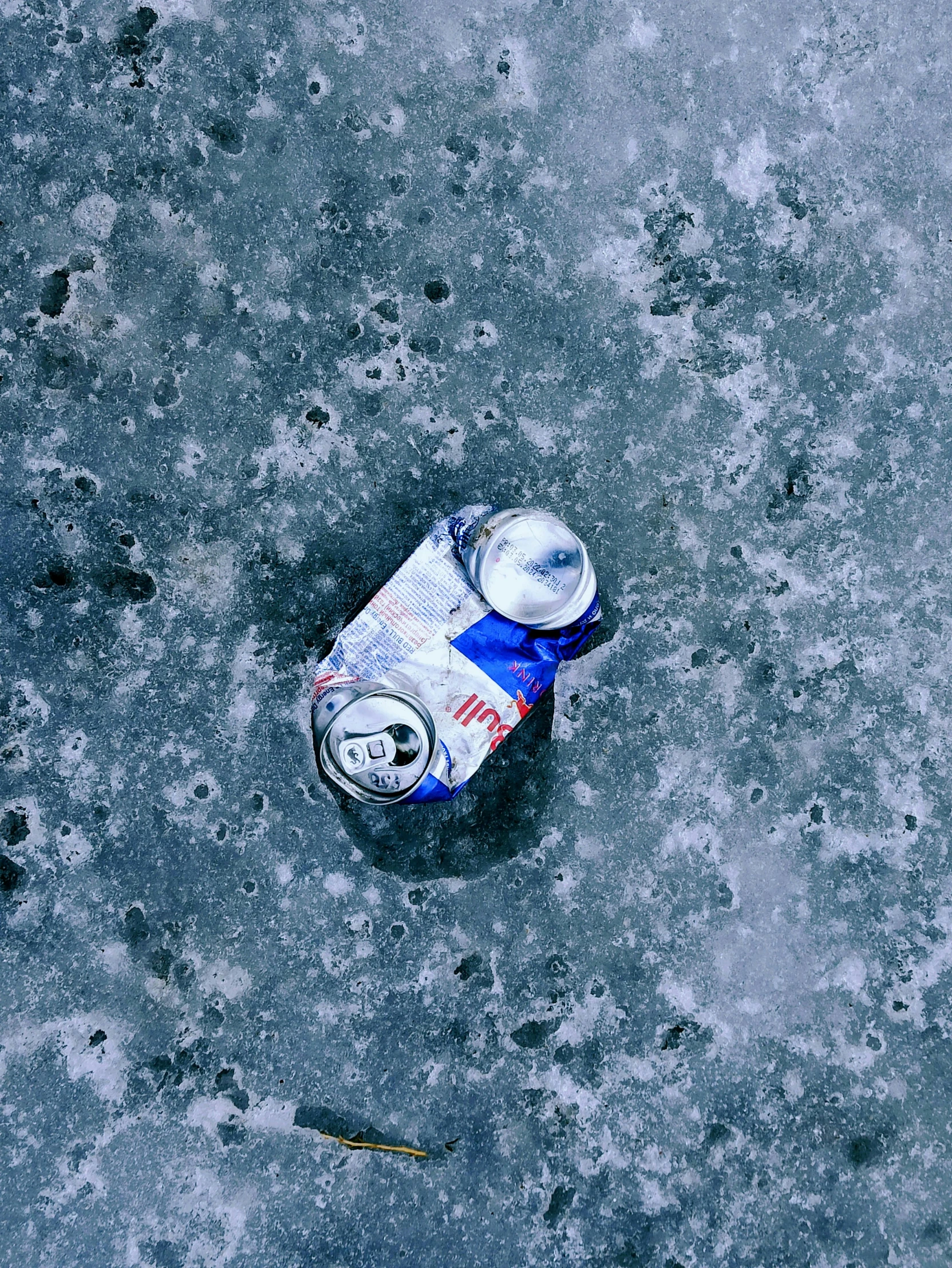 a can of soda on the concrete ground