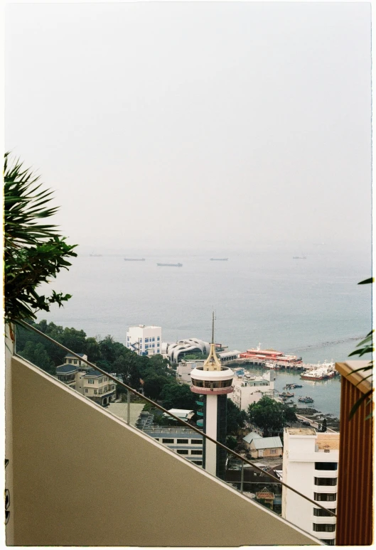 a cloudy city sits in the distance over looking a harbor