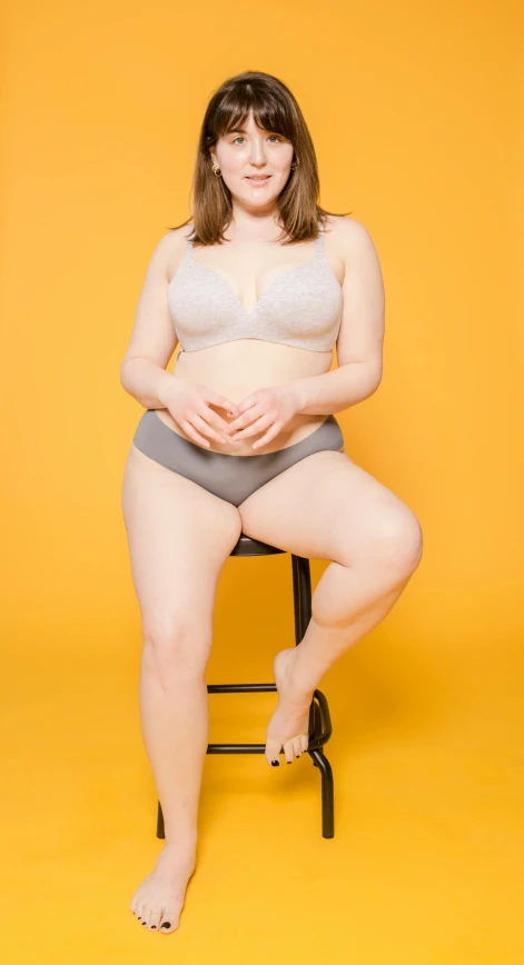 a woman in lingerie is sitting on a chair