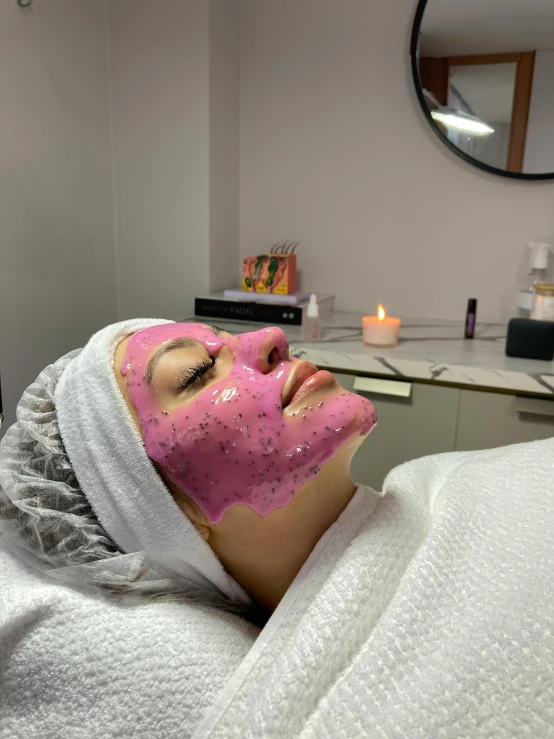 a woman who is laying down in a salon mask
