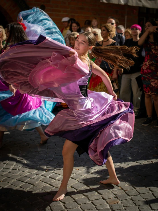 a girl is dancing in a colorful dress