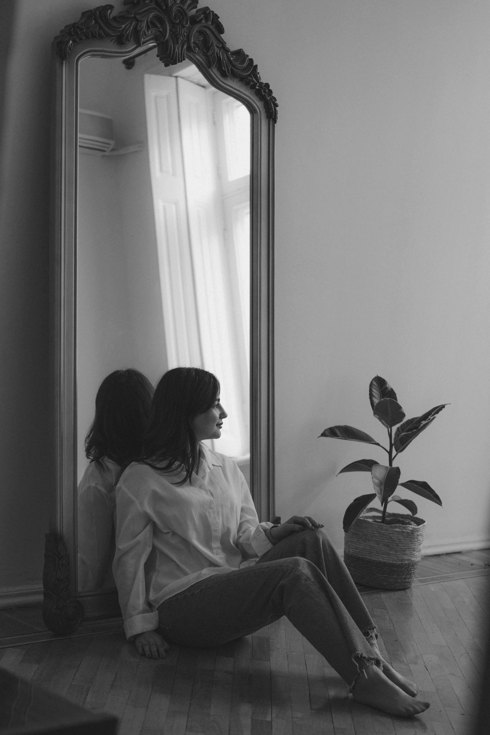 a woman sitting in front of a mirror in a room