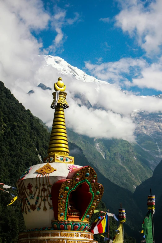 a statue stands with snow capped mountains behind it