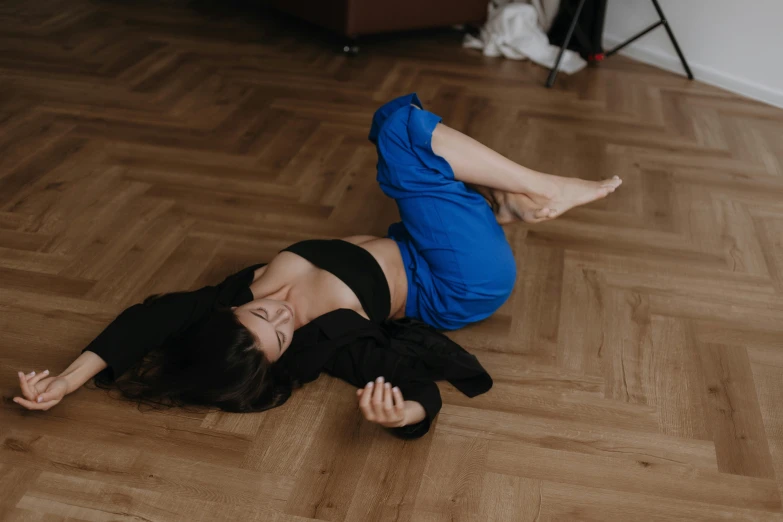 a woman is laying on the floor holding her hand out and looking to her side