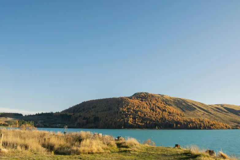 a mountain and a blue lake with water and grass