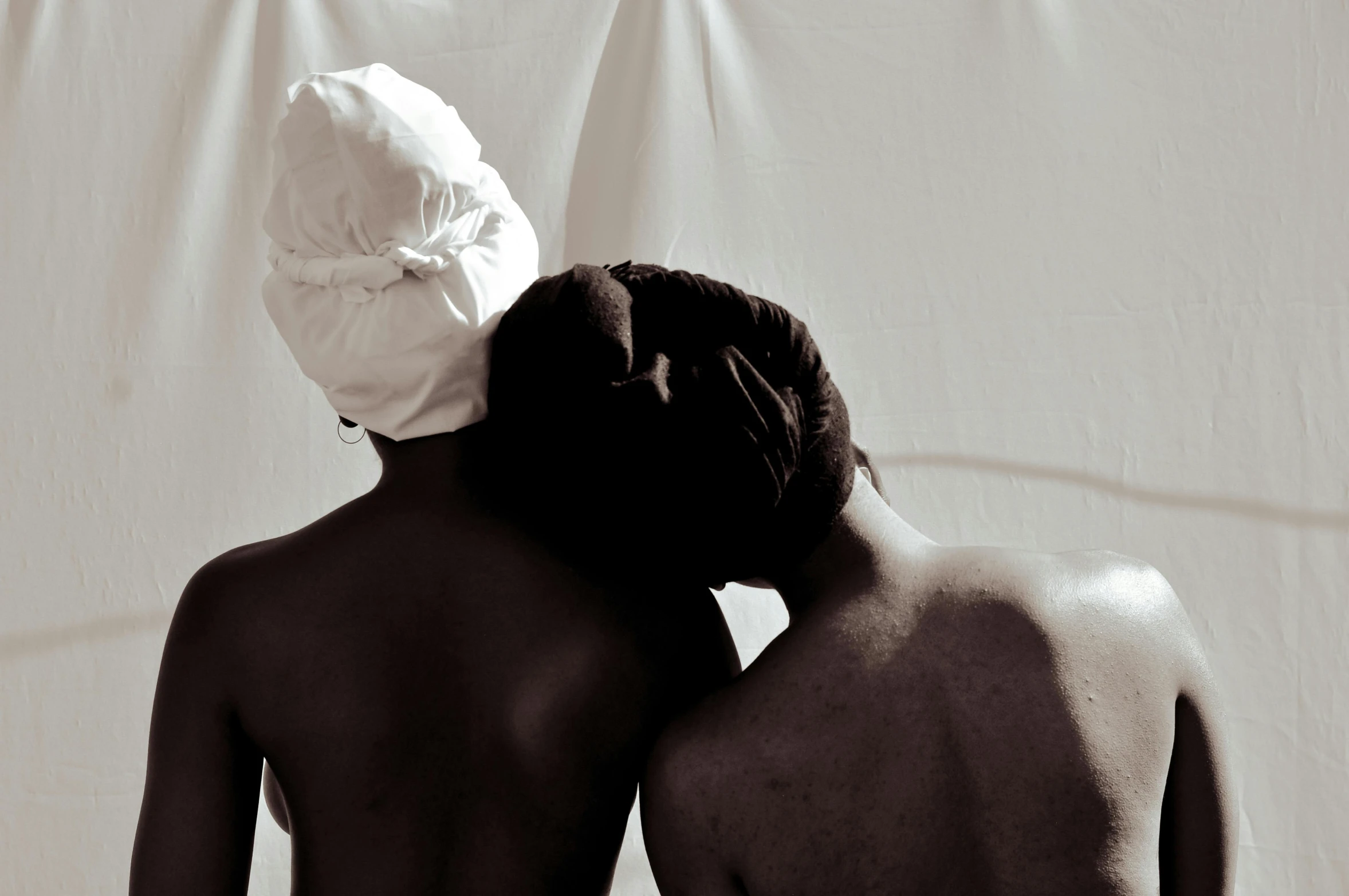 two black women in back covered up by a towel