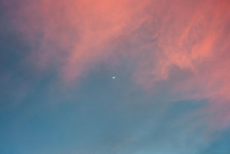 the clouds in the sky are red and pink