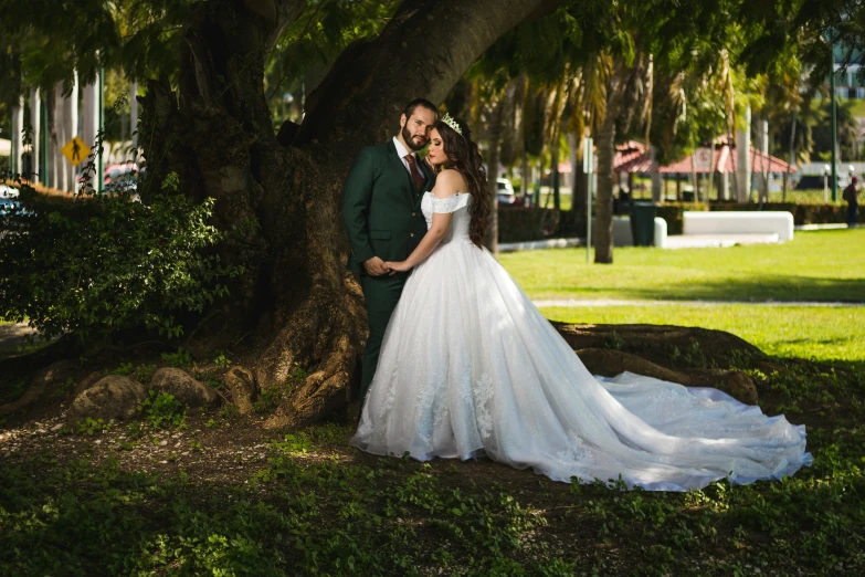 a man and woman are posing near a tree