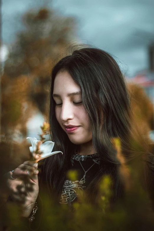 woman with long hair holding up a teacup in her right hand