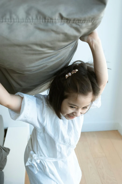 a small  holds a pillow in her arms