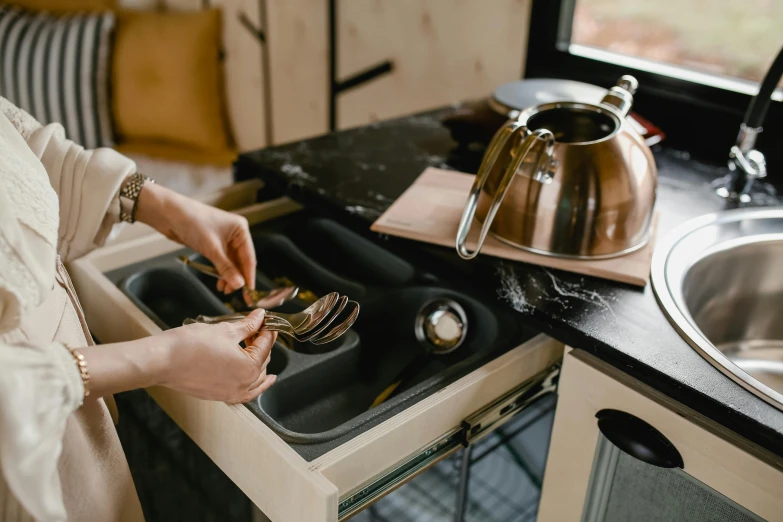 a person putting some items into a kitchen sink