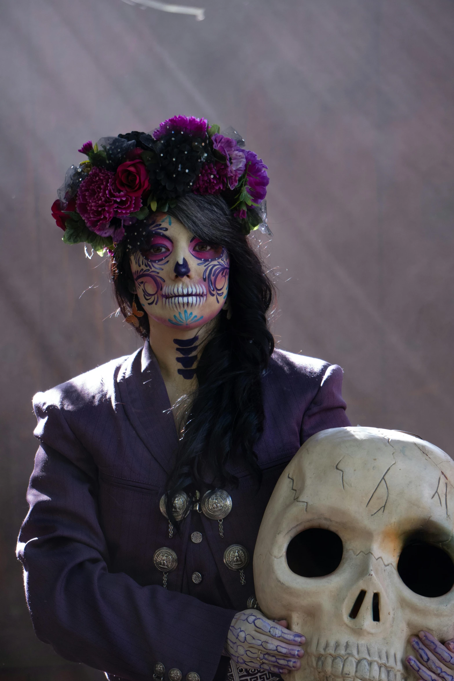 a woman holding a large skull with colorful makeup