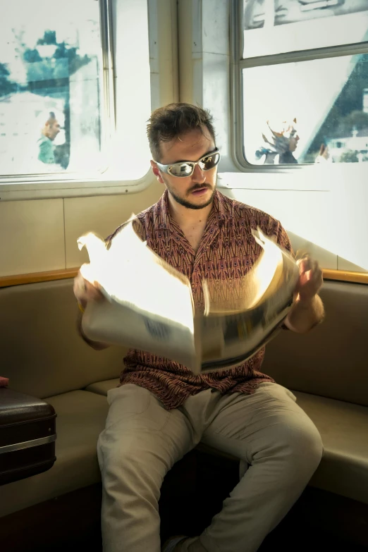 a man sitting on a bench reading a newspaper