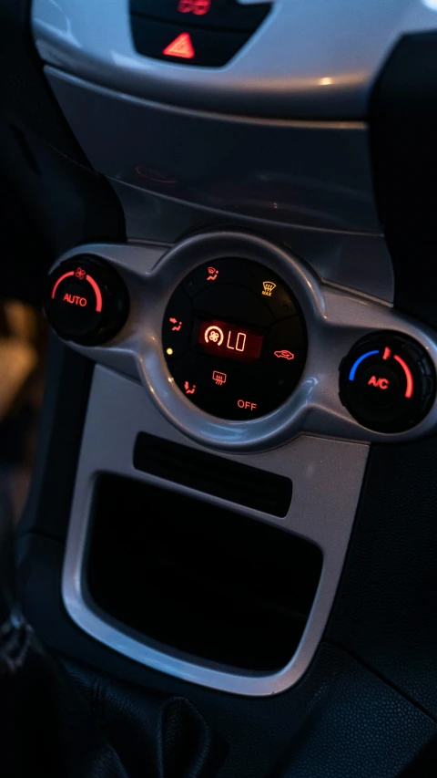 a car dashboard with a clock, air conditioner and radio