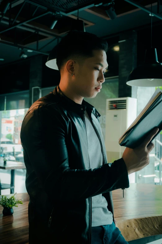 a man wearing a black hat looks down at his book