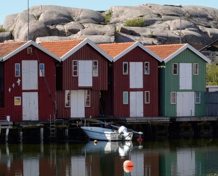 there are some boats in the water by the huts