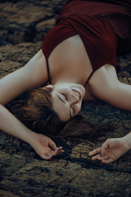 woman in red dress laying on dirt ground