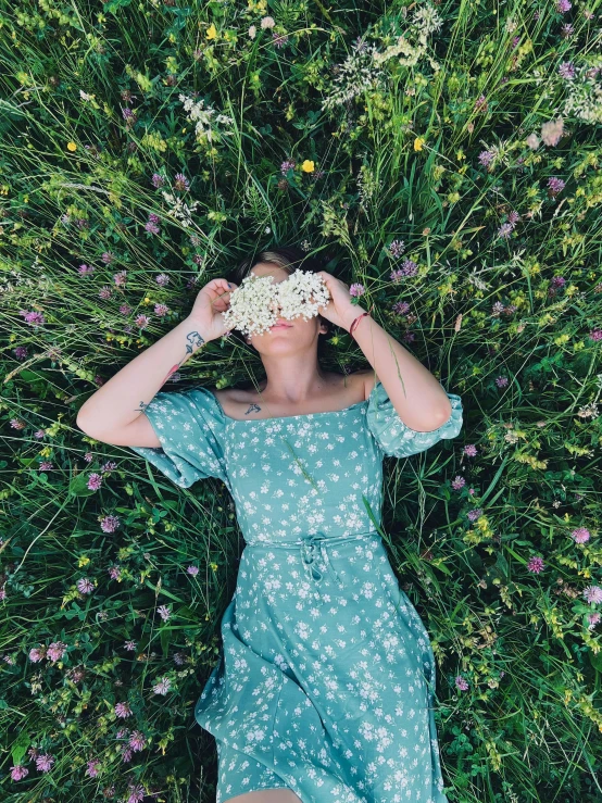 a person laying down in a field surrounded by plants