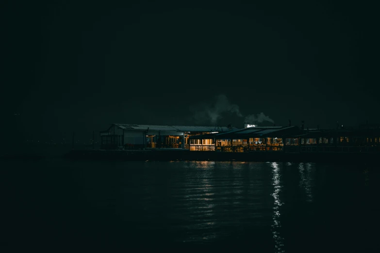 a building next to the water at night