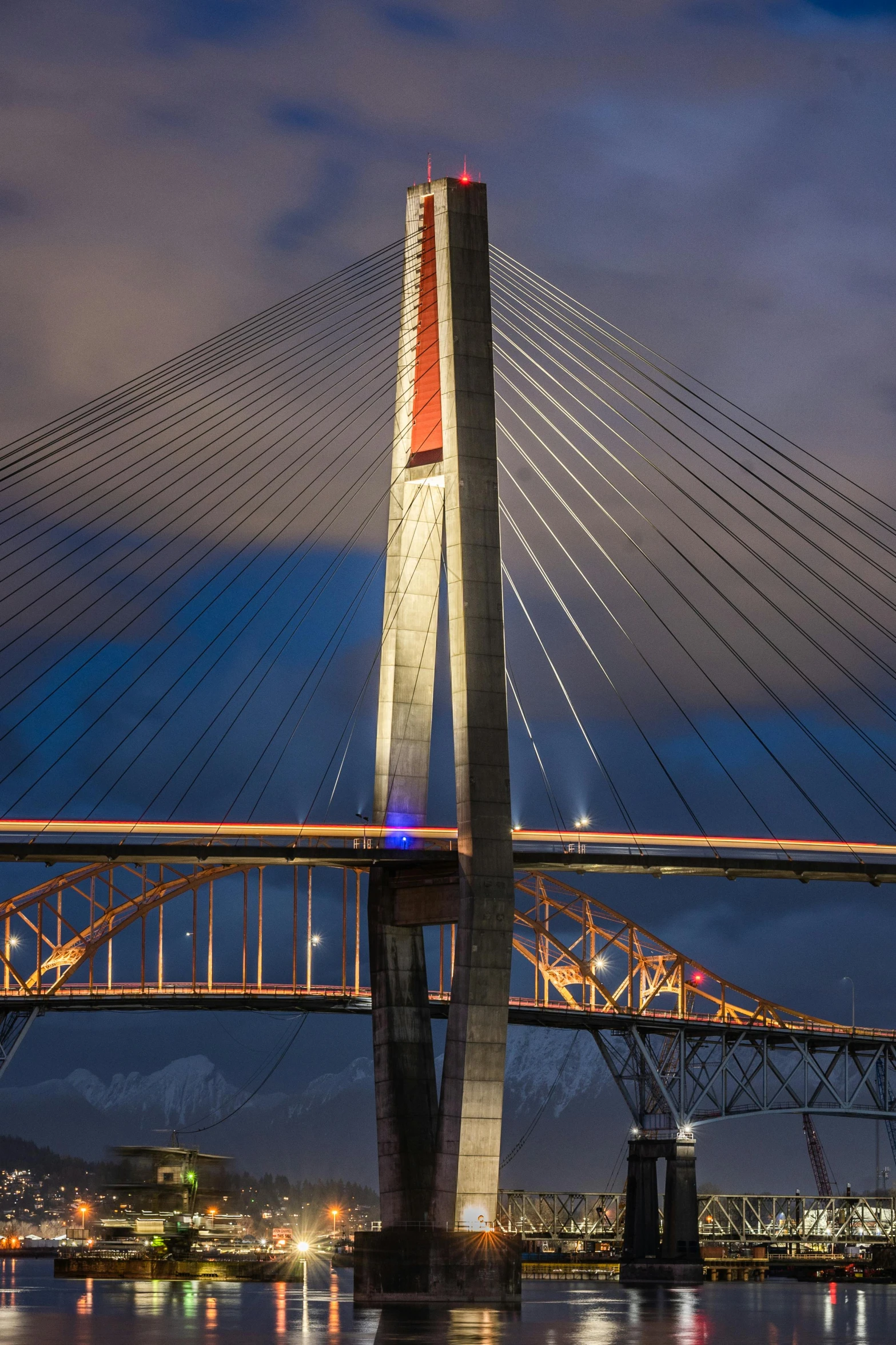 a bridge lit up with blue, orange, and red lights