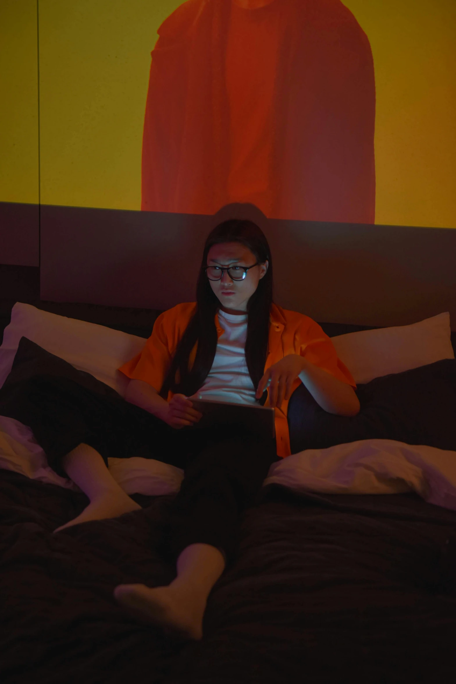 a girl with glasses reading a book on a bed