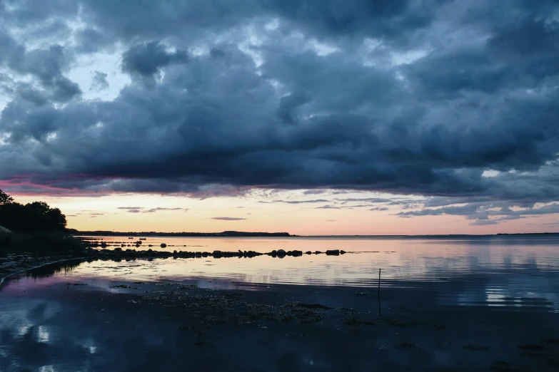 the sky is cloudy at the beach shore