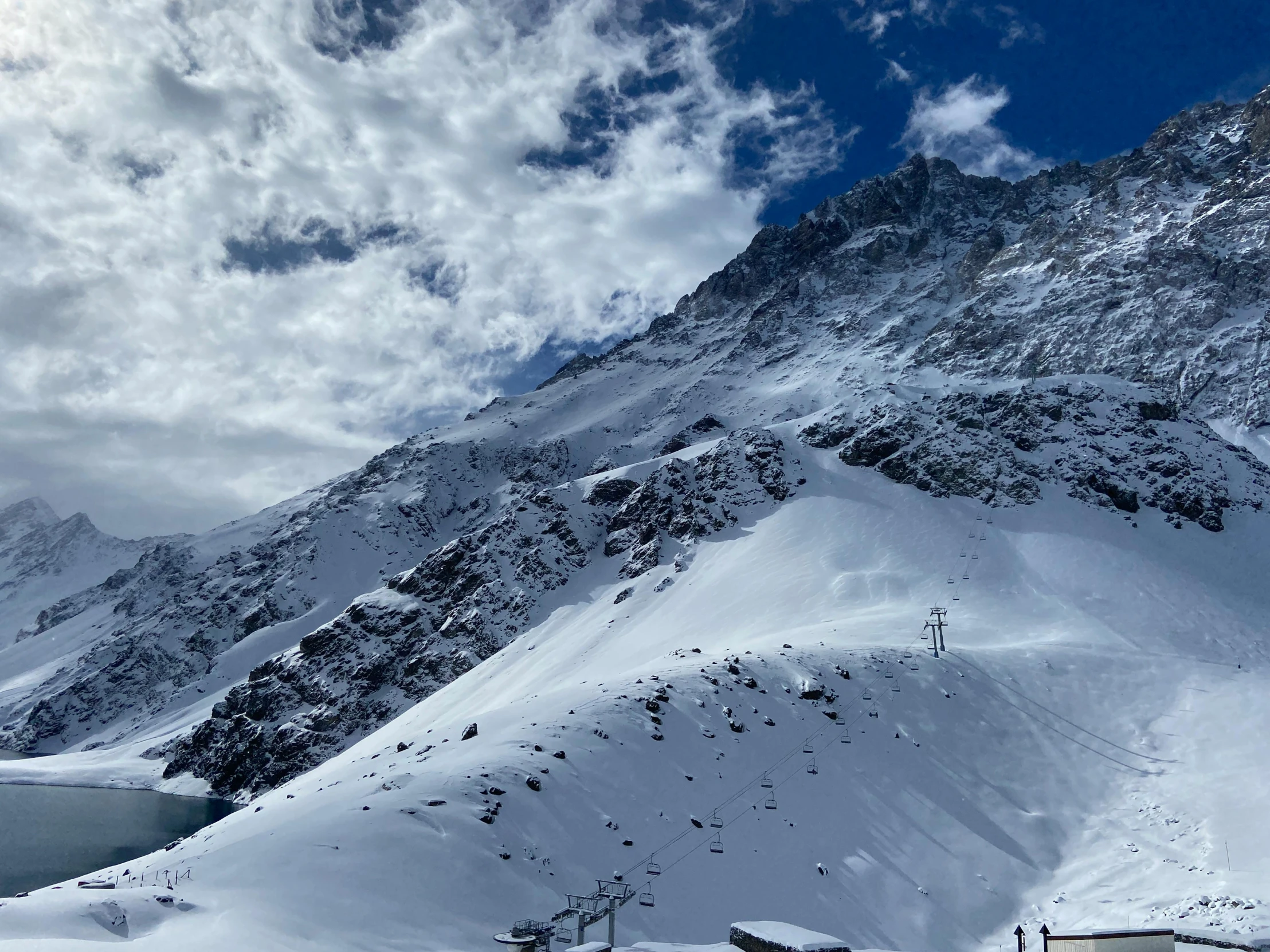 the mountain side is covered in snow, with people on skis