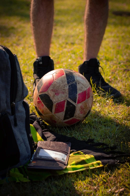 there is a man sitting on the grass with a soccer ball