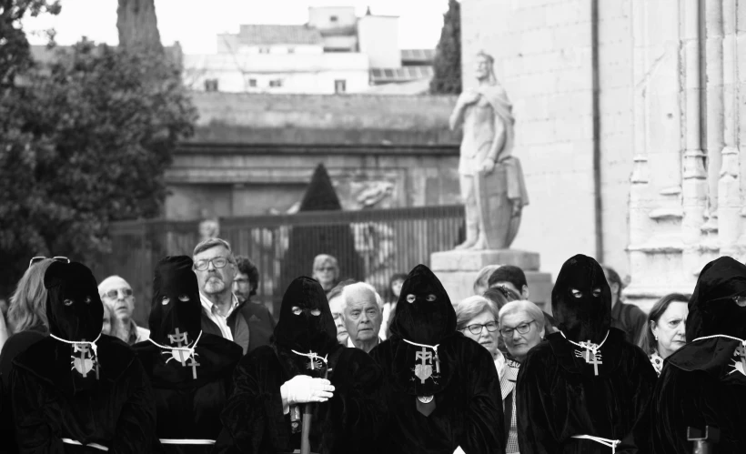 black - and - white pograph of people wearing garb