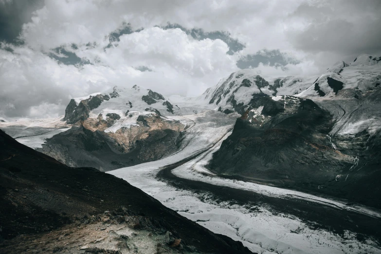 snow covered mountains and valleys during a cloudy day