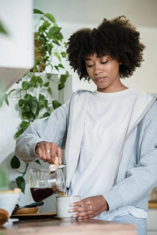 a woman is preparing a cup of liquid