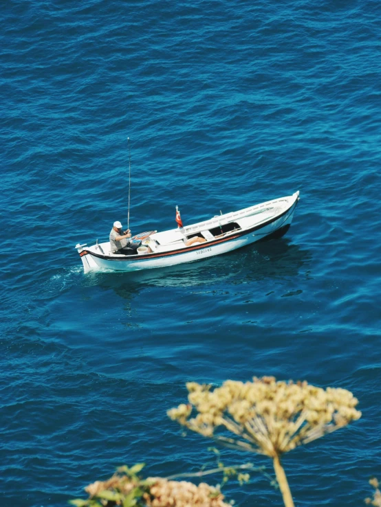 a man on the back of a boat with a fishing pole