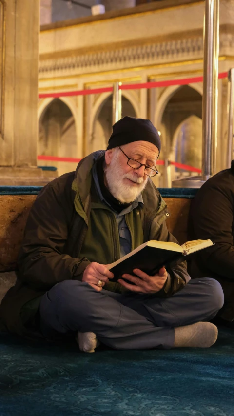 a man reading a book on a city street