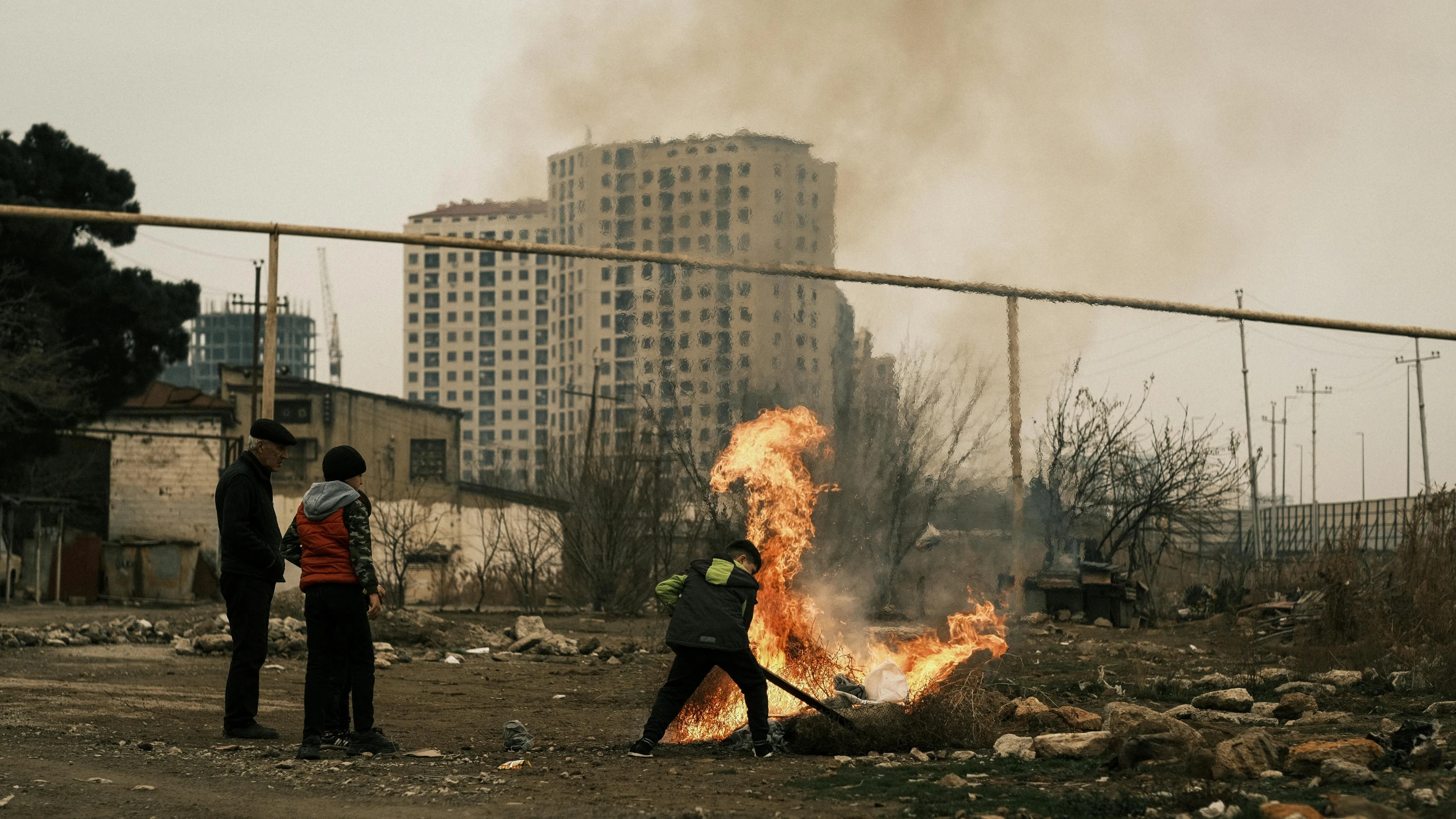 people in the dirt near a fire with a large flame