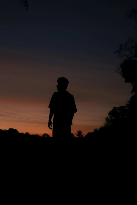 a silhouette of the man in black on a dark sunset