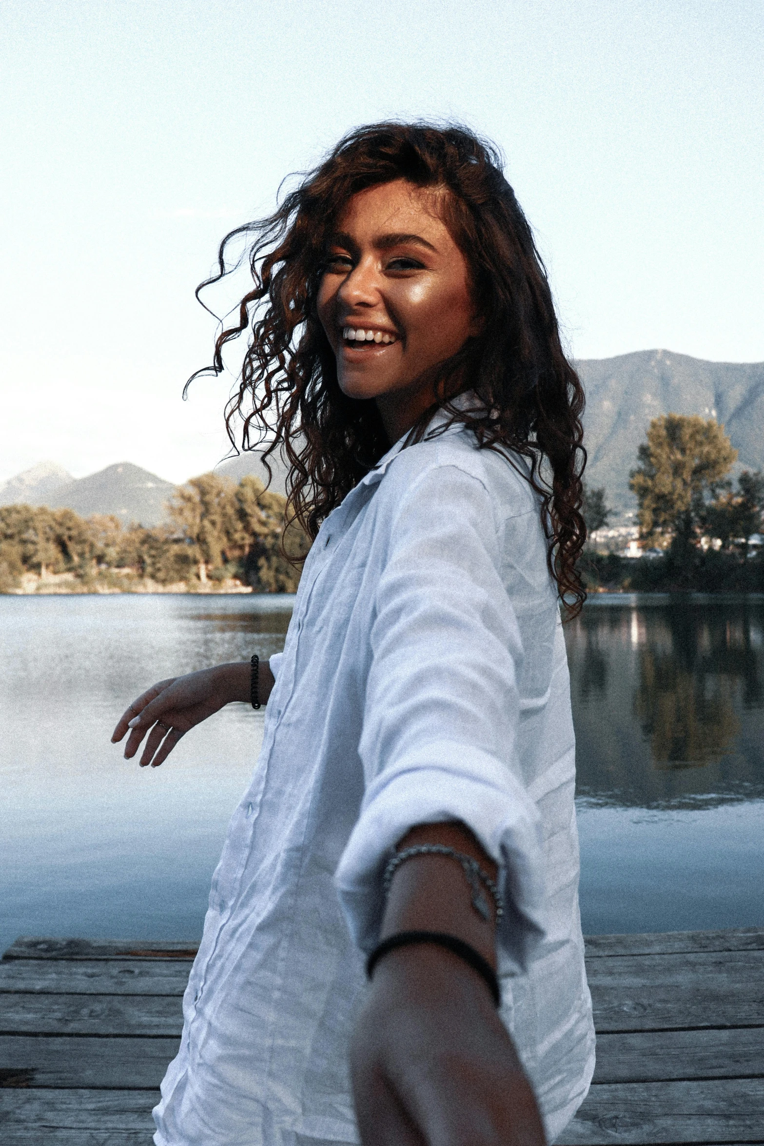 a girl is walking along the dock on the water