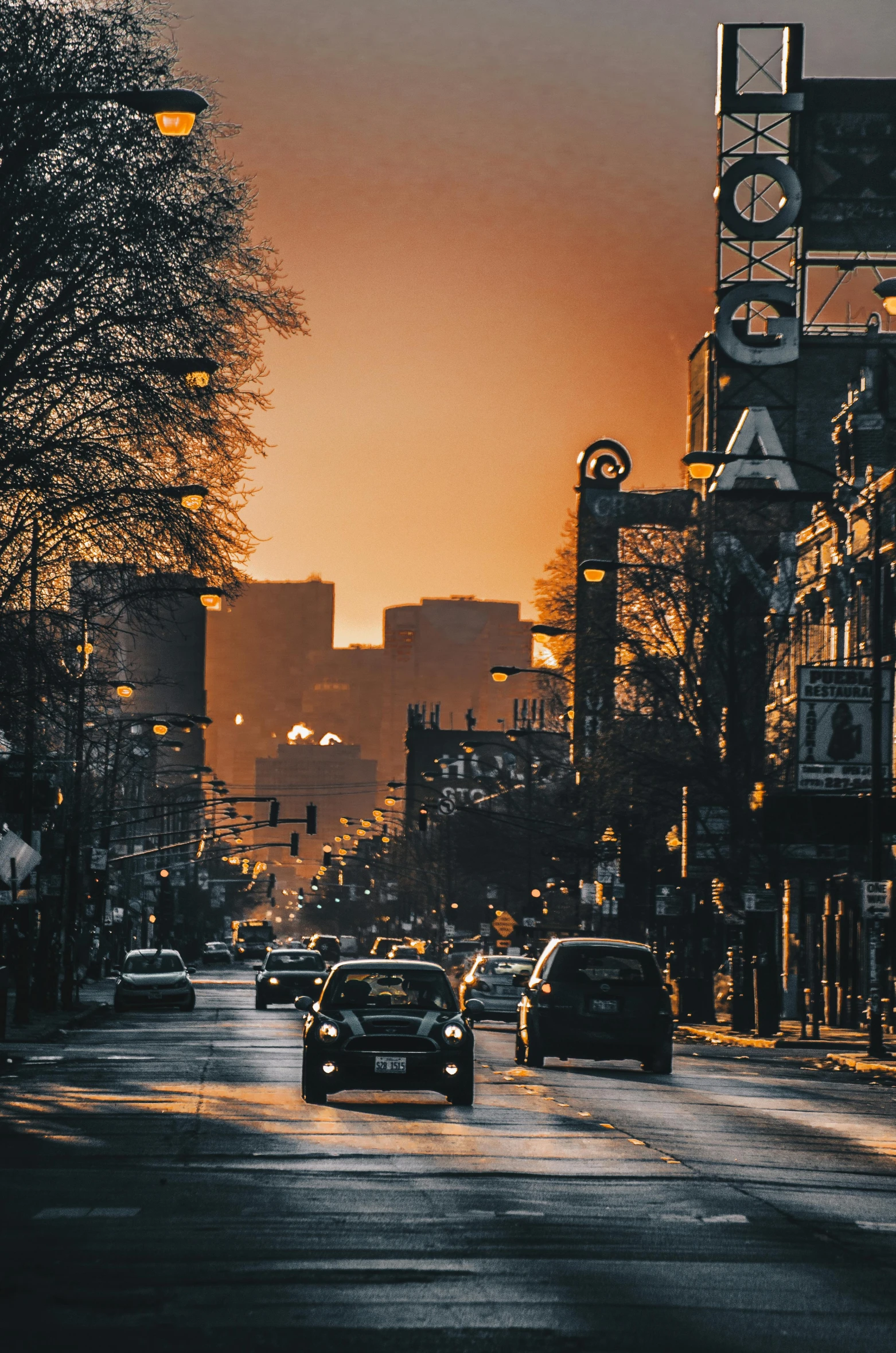 a group of cars drive down a street near some buildings