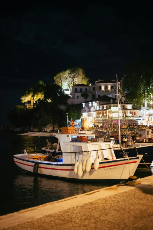 two boats tied up to the shore at night